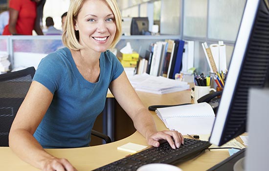 smiling blond woman at computer